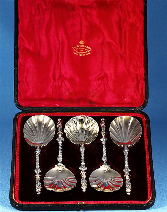 A cased set of four Victorian silver parcel gilt fruit serving spoons and a sugar sifter, spoon 197mm, weight 12.4oz/388 grms.